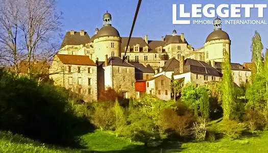 Une haute bâtisse avec terrasse, vue panoramique, dans un village historique avec commerces et châ