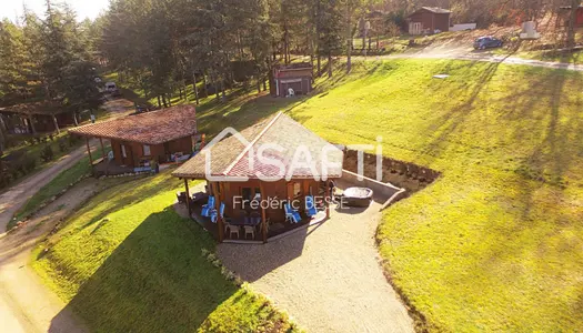 Chalet bois dans parc arboré avec piscine.