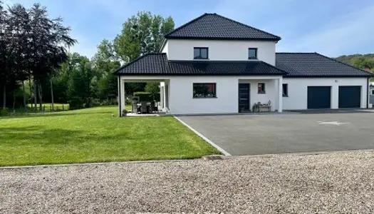 Maison contemporaine avec étang et chalet.